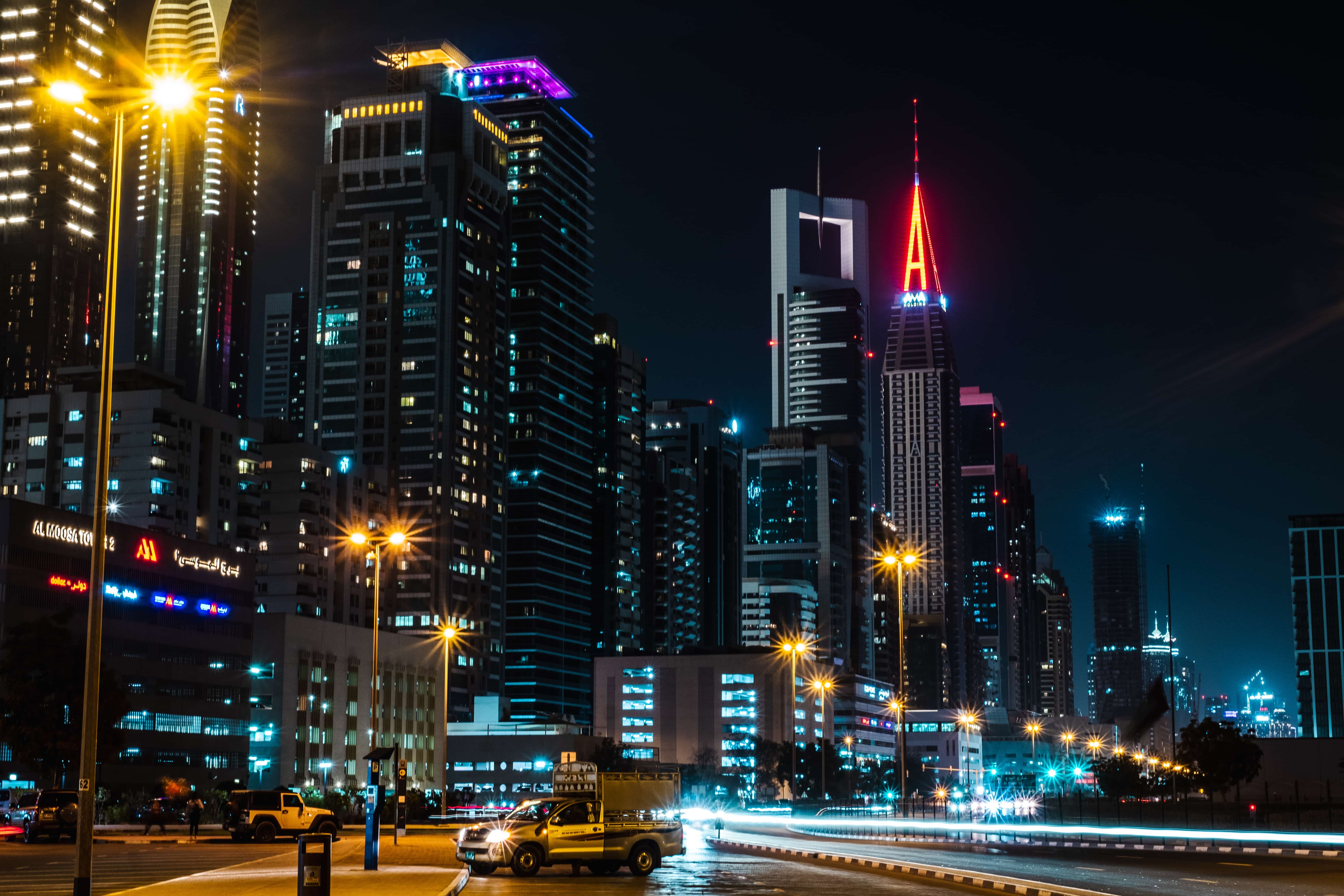Communities A vibrant city skyline at night, featuring illuminated skyscrapers and glowing streetlights.