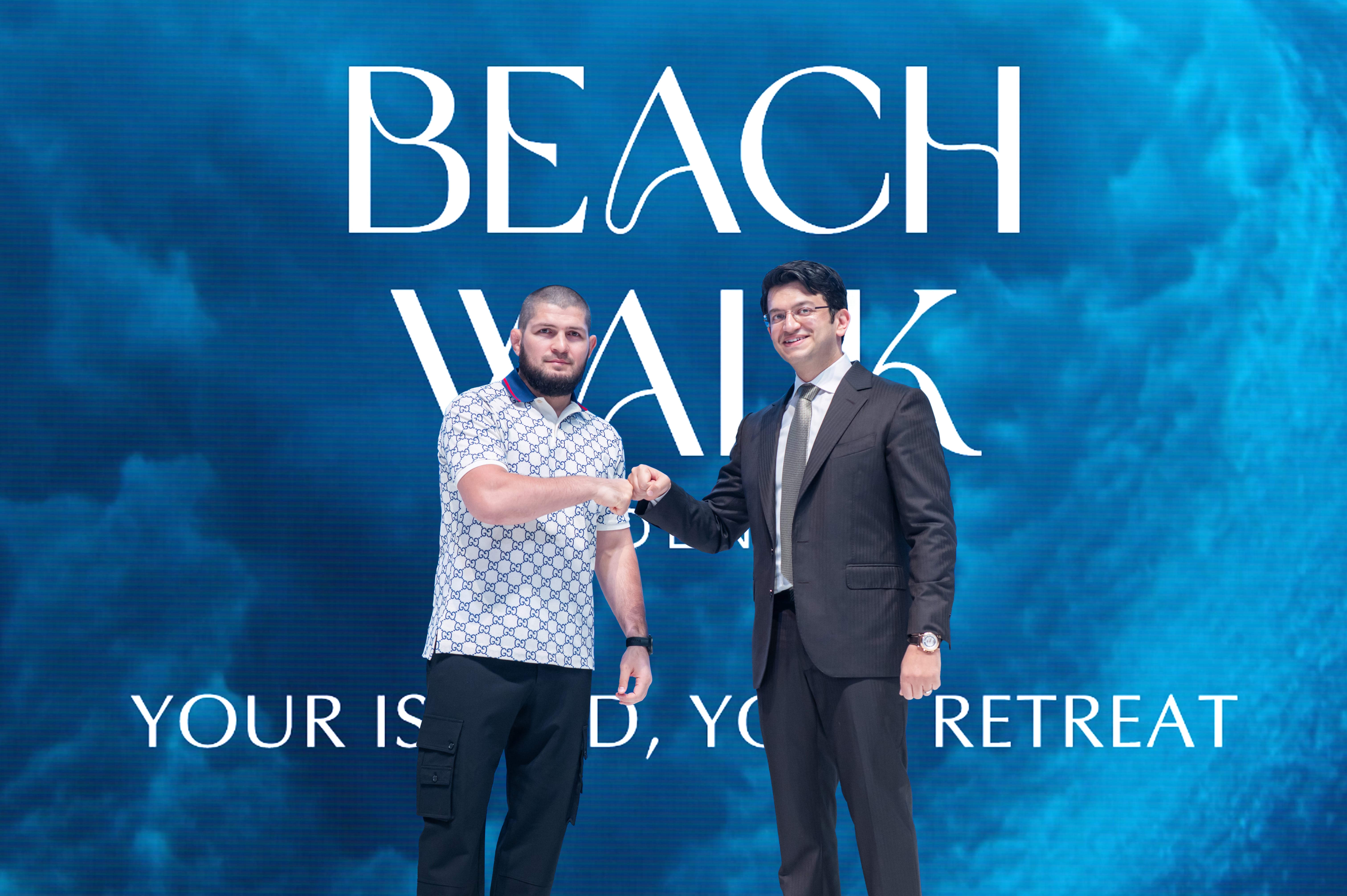 Events?Page=3 Two men are shaking hands against a blue backdrop with the text "BEACH WALK YOUR ISLAND, YOUR RETREAT."