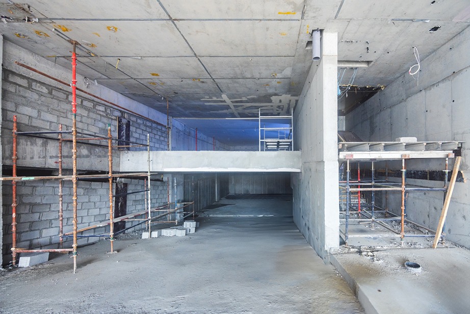 Pearl House By Imtiaz An unfinished construction site featuring scaffolding, concrete walls, and a work platform above a lower level.