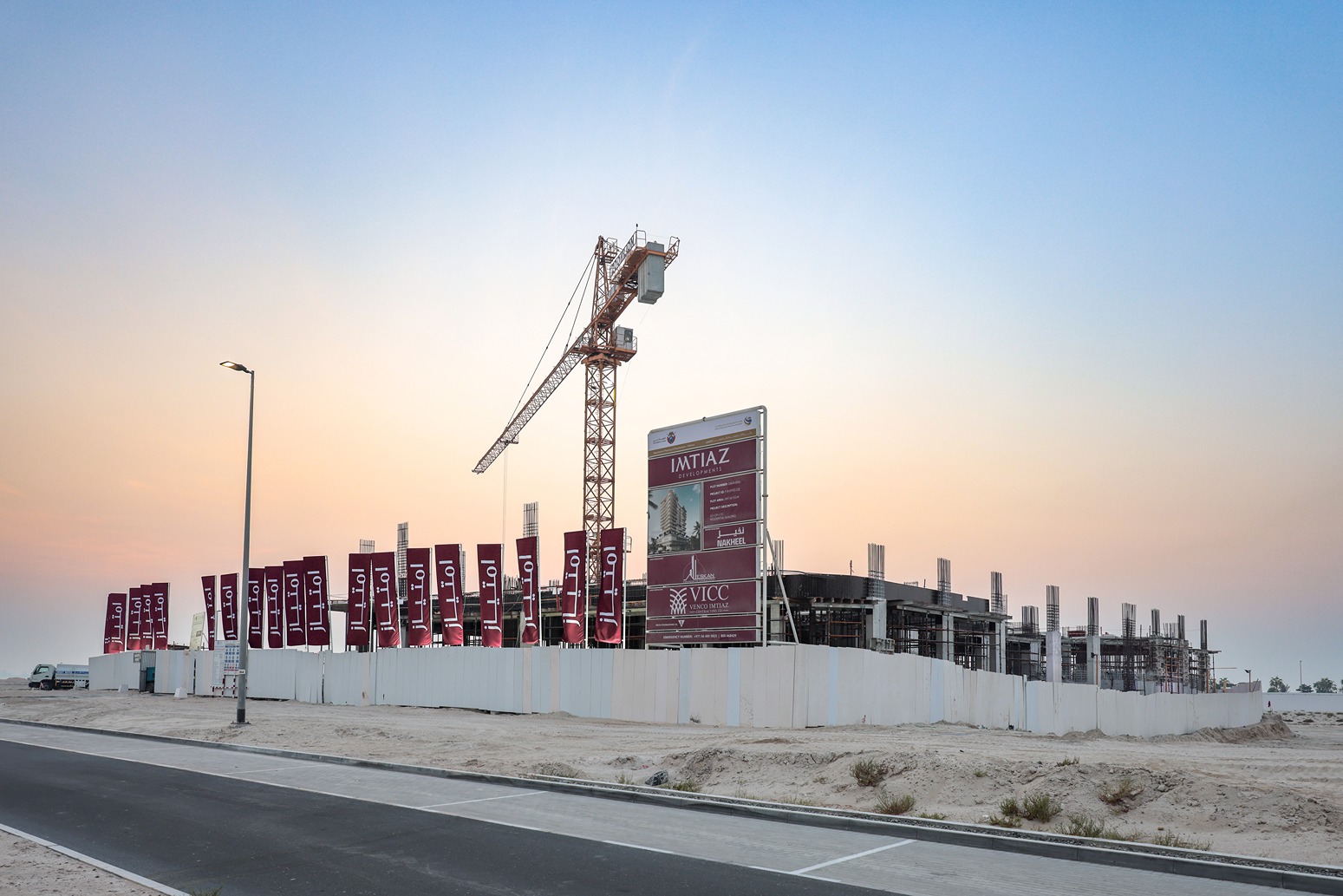 Beach Walk Residence Construction site with a large crane, signage, and framed structures against a soft sunrise sky.