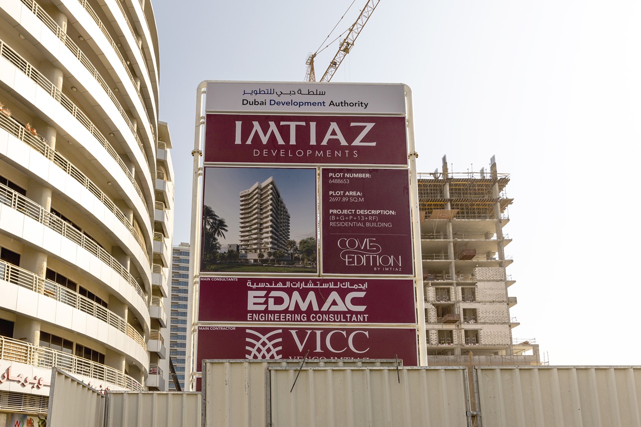 Cove Edition I By Imtiaz 1 Construction site sign detailing project information for a residential building in Dubai, with adjacent building visible.