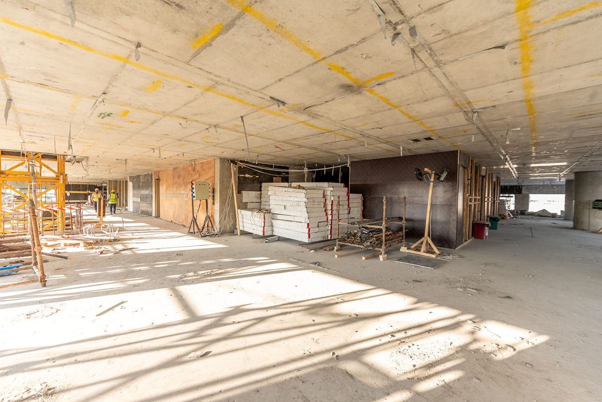 Beach Walk Residence Interior of a construction site featuring scaffolding, stacked materials, and construction workers in safety gear.