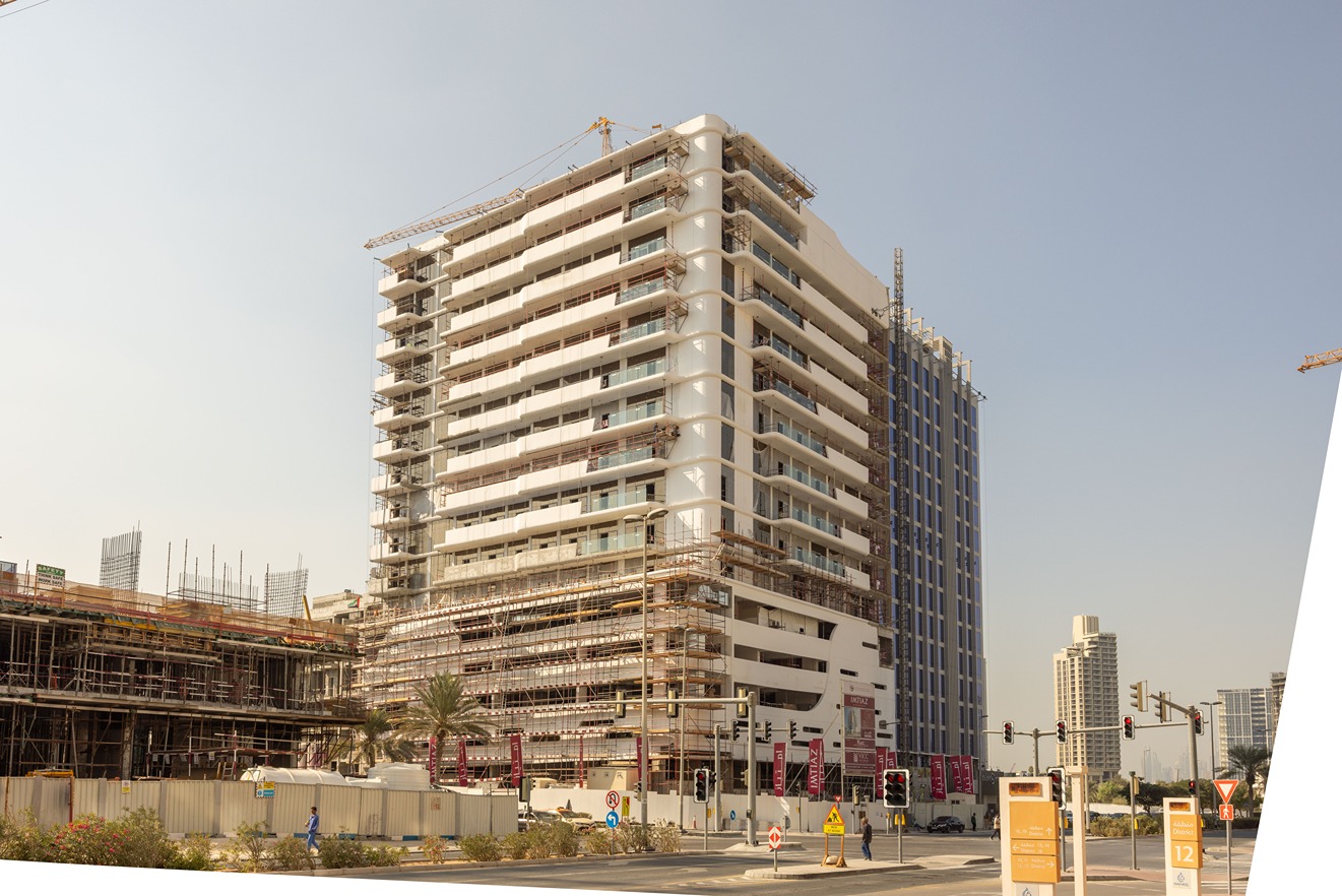 Pearl House By Imtiaz A modern building under construction with scaffolding, surrounded by ongoing development and construction equipment.