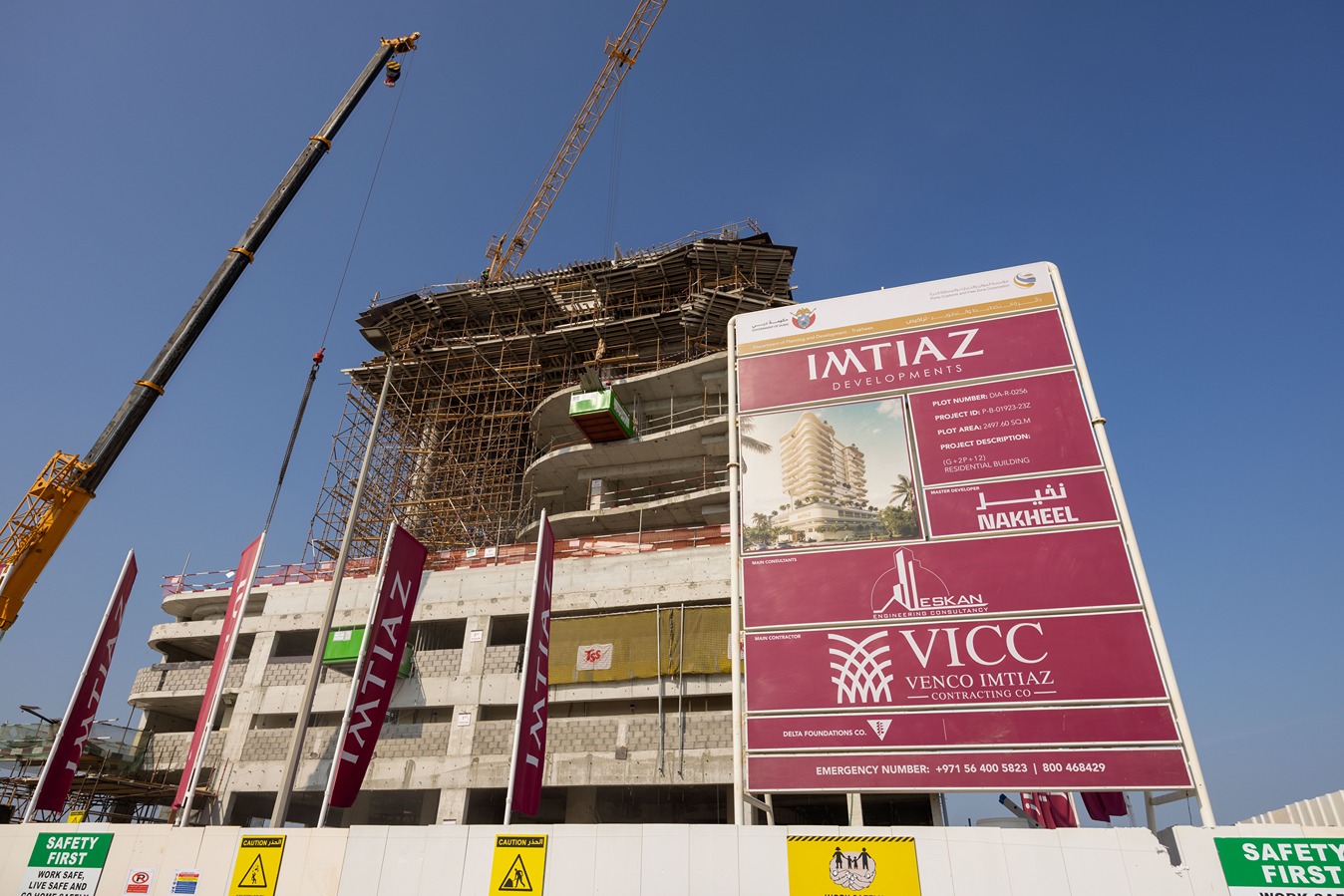 Beach Walk Residence Construction site featuring a partly completed building, a crane, and a large sign with project details.