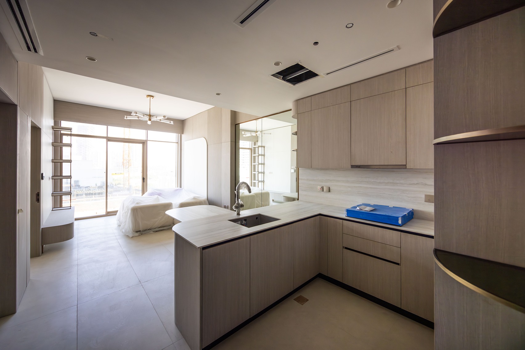 Pearl House By Imtiaz Modern kitchen and living area with a light wood design, large windows, and unfinished decor elements.