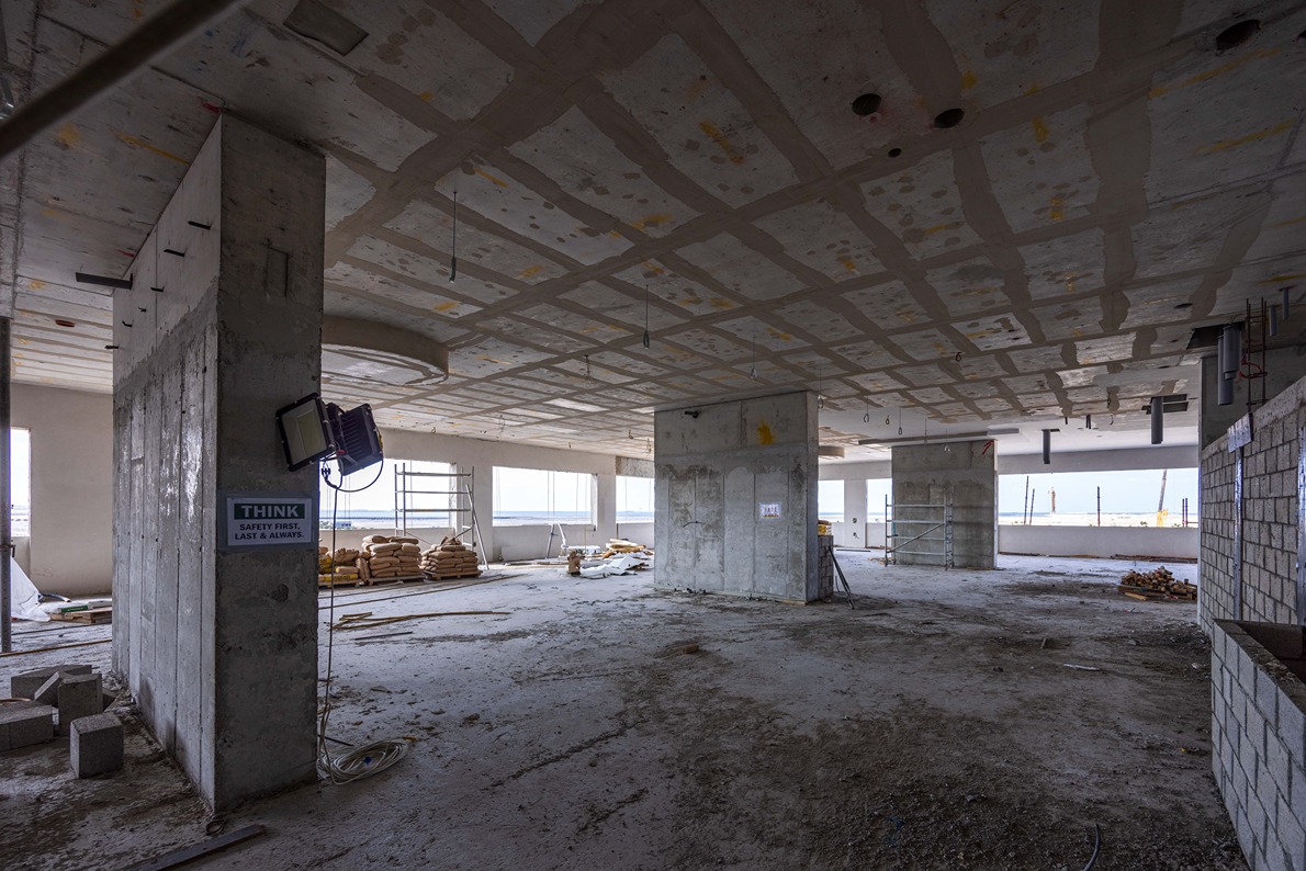 Beach Walk Residence An unfinished construction site featuring concrete walls, exposed ceilings, and stacks of building materials.