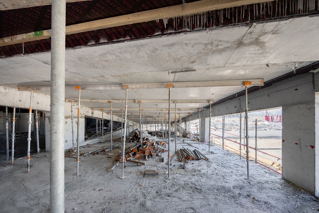 Beach Walk Iii By Imtiaz An unfinished construction site featuring scaffolding, concrete pillars, and scattered building material debris.