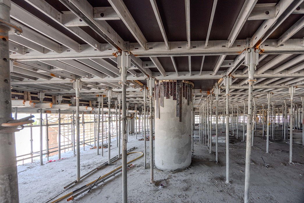 Beach Walk Iii By Imtiaz A view of a construction site showcasing scaffolding and concrete pillars under a building framework.