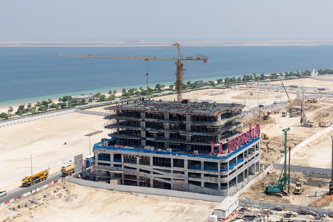 Beach Walk Iii By Imtiaz A construction site featuring a multi-story building under development, with cranes and machinery nearby.