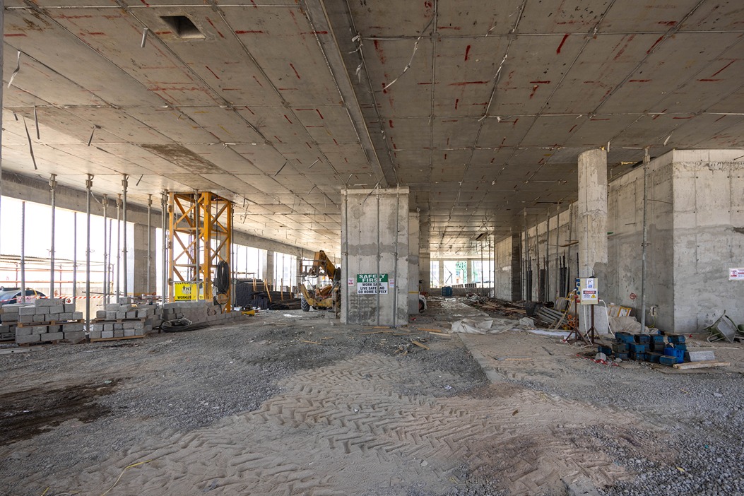 Beach Walk Iii By Imtiaz An empty construction site with concrete pillars, construction equipment, and scattered materials on the ground.