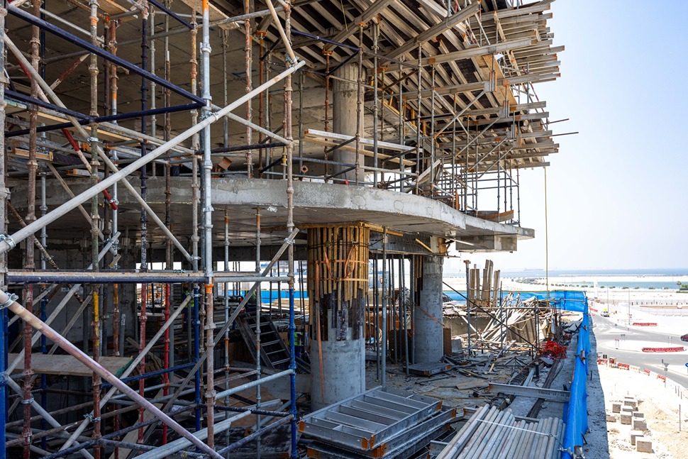 Beach Walk Iii By Imtiaz Construction site with scaffolding, exposed concrete structures, and views of the surrounding area in the background.