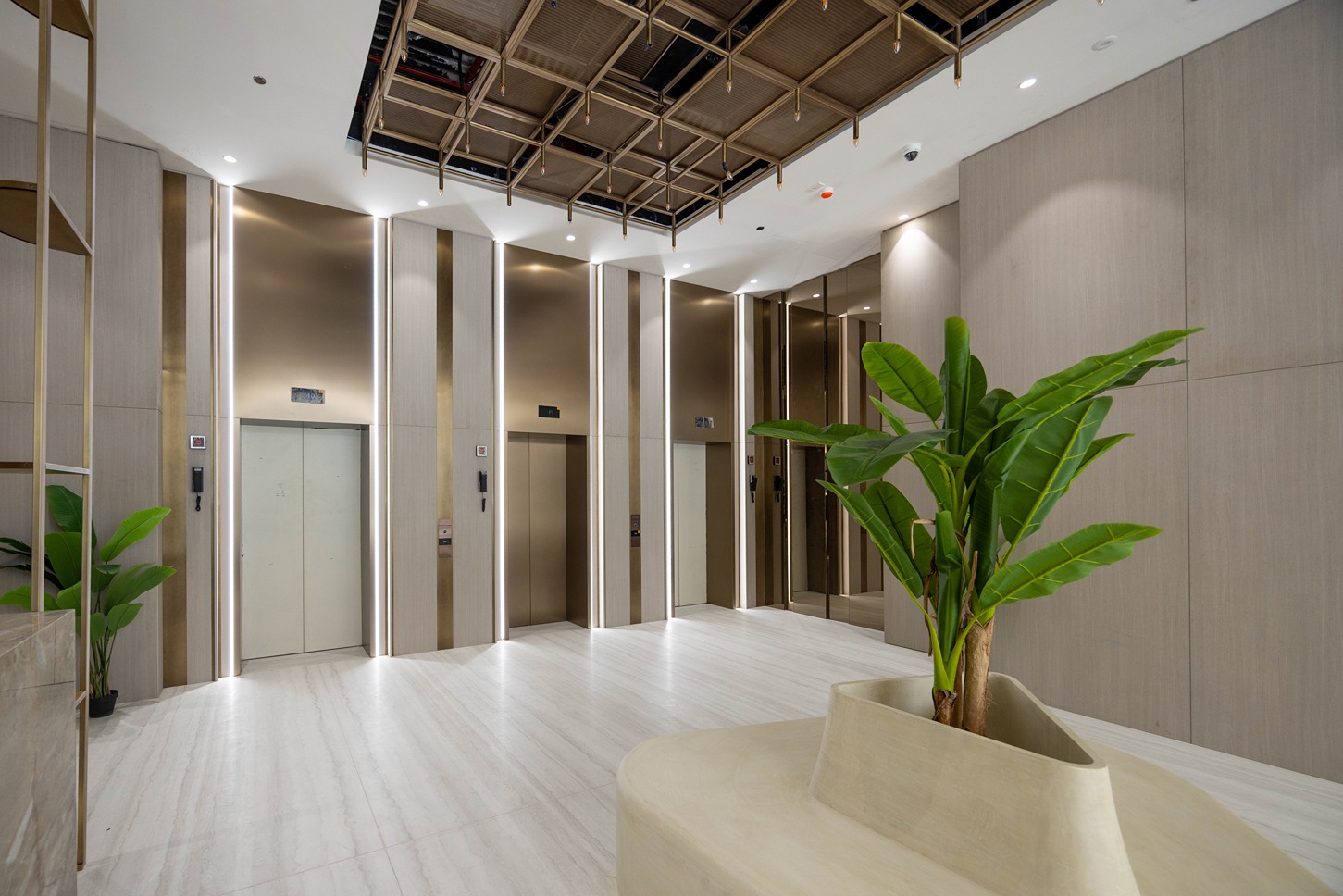 Pearl House By Imtiaz A modern lobby featuring elevators, elegant lighting, and a decorative plant in a minimalist design.