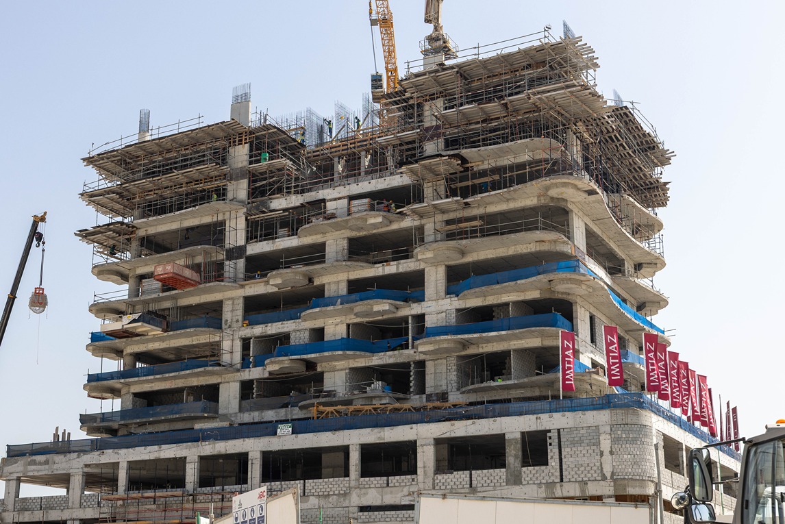 Beach Walk Residence A partially constructed building with scaffolding, multiple floors, and construction workers visible.