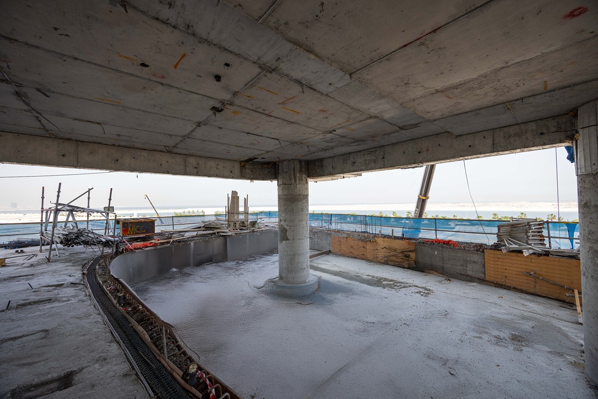Beach Walk Iii By Imtiaz View of an unfinished building interior with concrete pillars, scattered construction materials, and exposed beams.