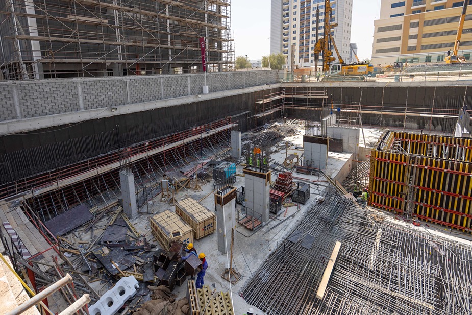 Cove Edition I By Imtiaz 1 Construction site showing deep excavation, scaffolding, rebar, and construction materials in an urban environment.