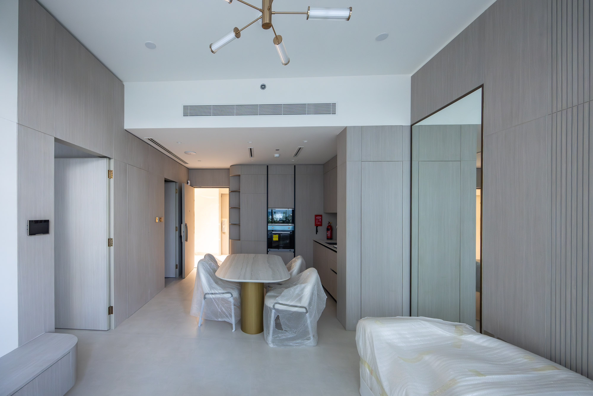 Pearl House By Imtiaz A modern interior featuring a dining table with chairs, sleek cabinetry, and minimalistic decor in neutral tones.