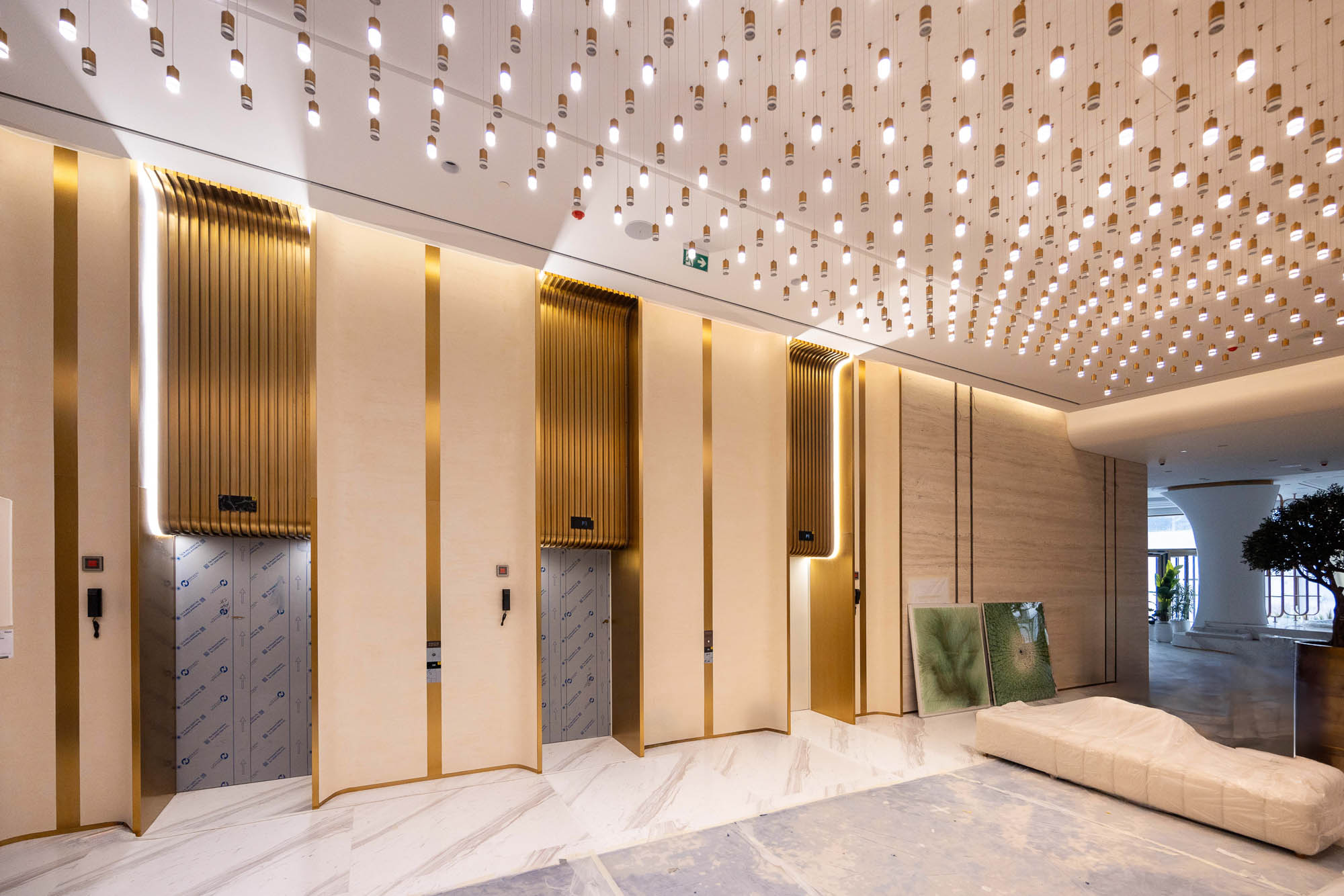 Beach Walk Residence Modern lobby space featuring golden elevator doors, elegant lighting, and contemporary decor elements.
