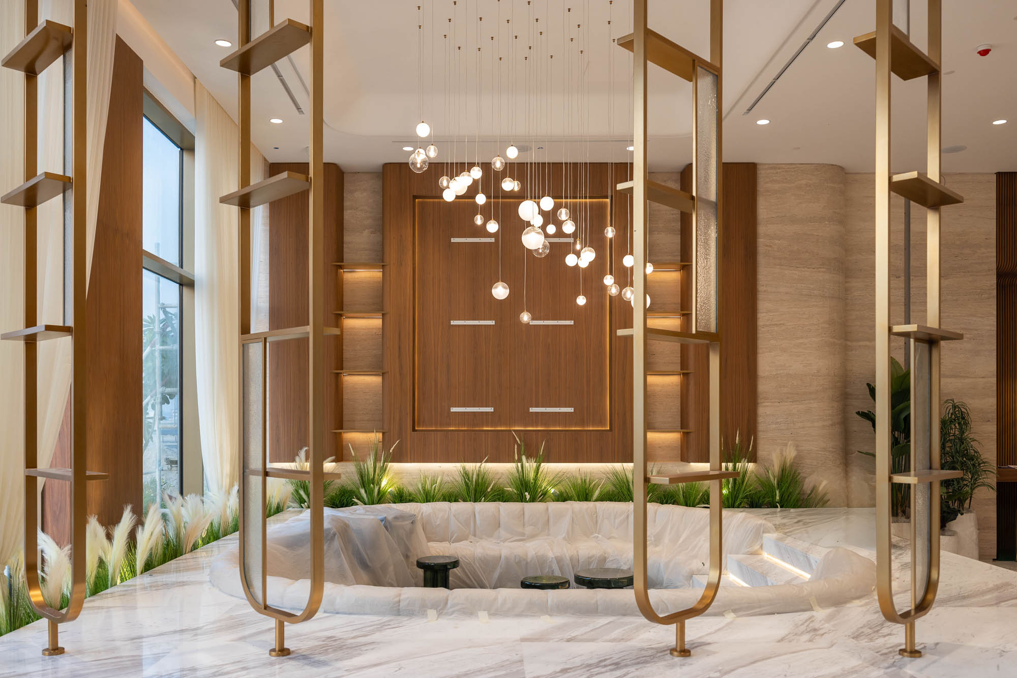 Beach Walk Residence A modern interior with gold accents, elegant lighting, and decorative plants around a stylish seating area.