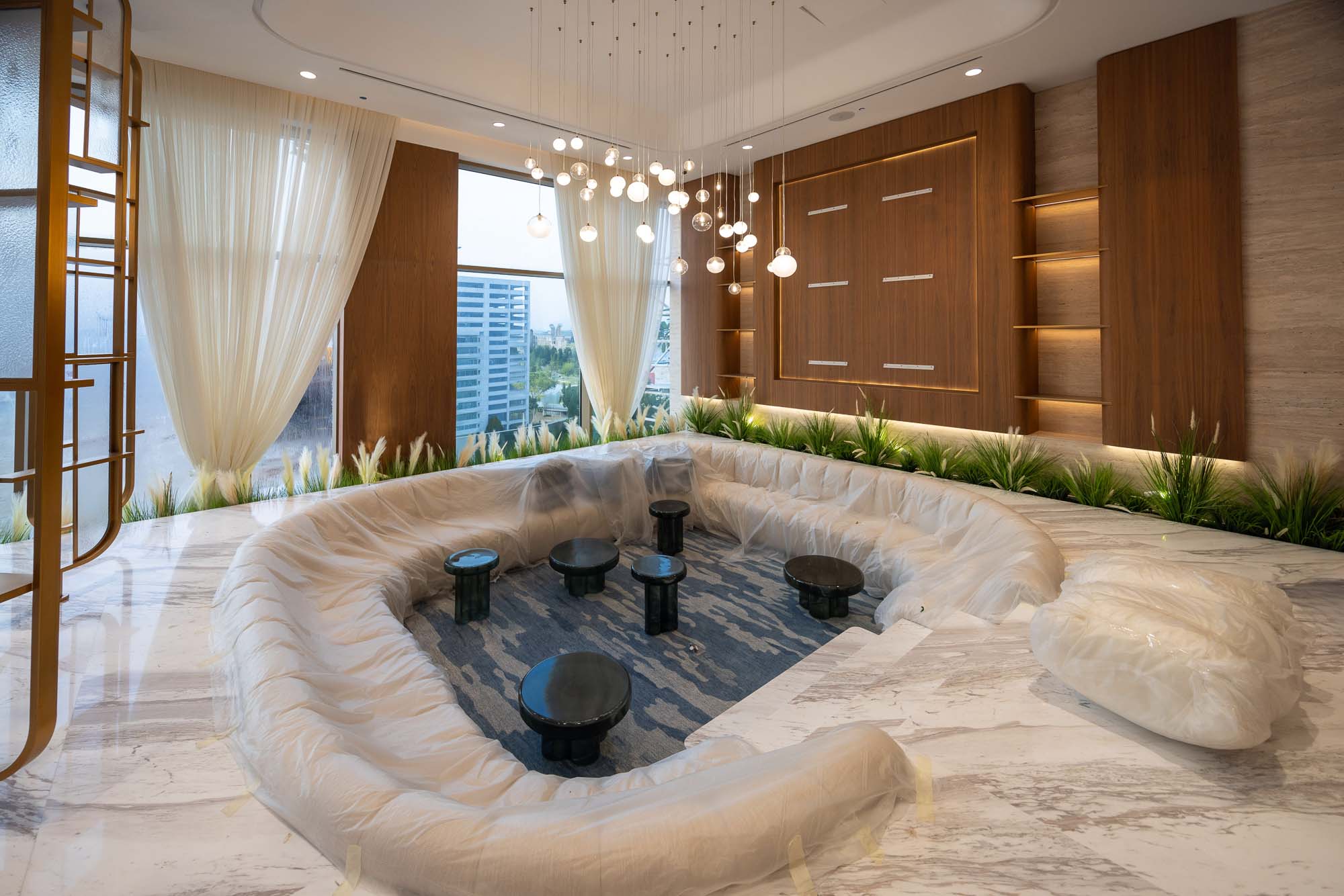Beach Walk Residence Modern lounge area featuring a circular, cushioned seating arrangement, black tables, and elegant lighting.