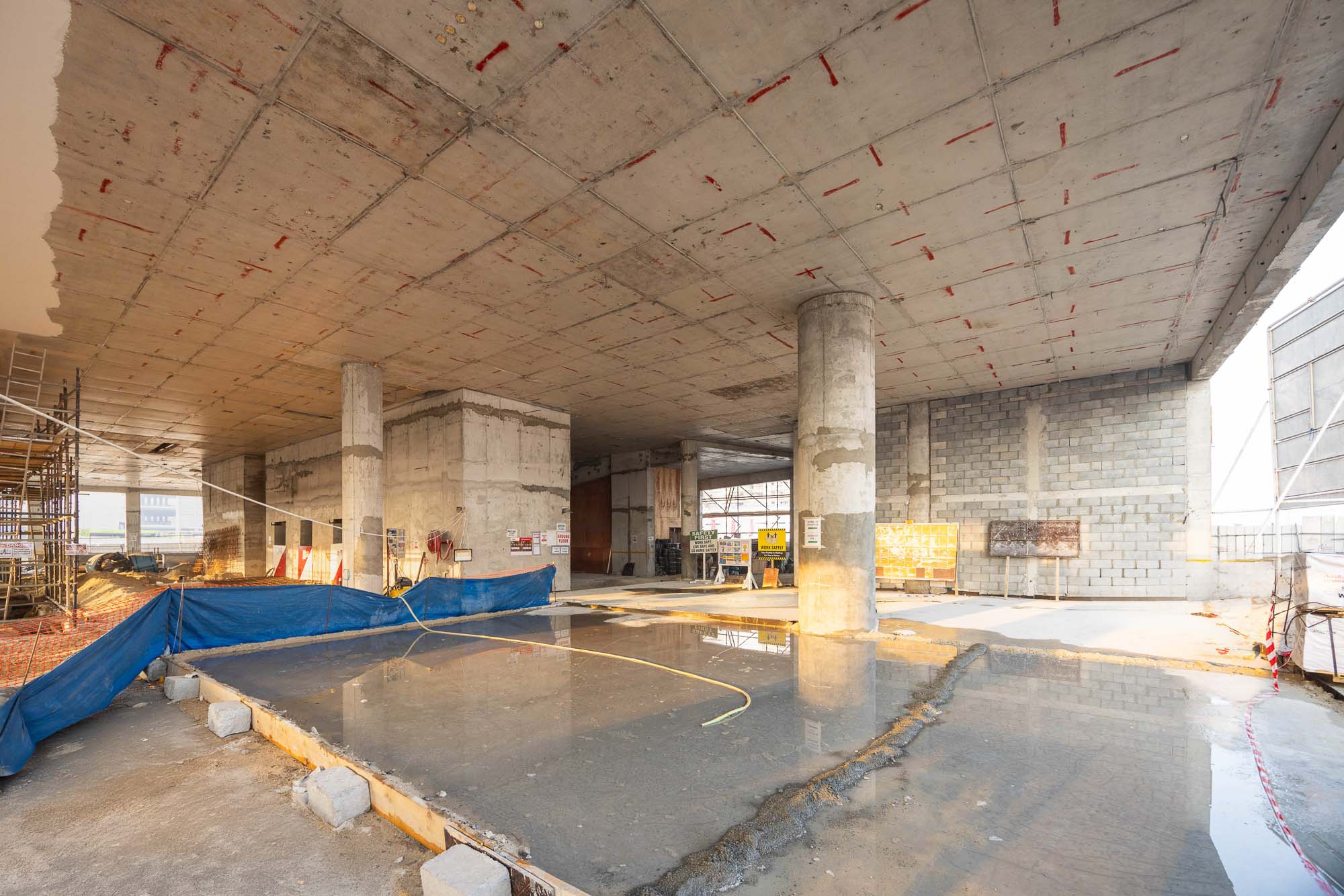 Beach Walk Iii By Imtiaz Construction site interior showing concrete columns, unfinished flooring, and construction materials scattered around.