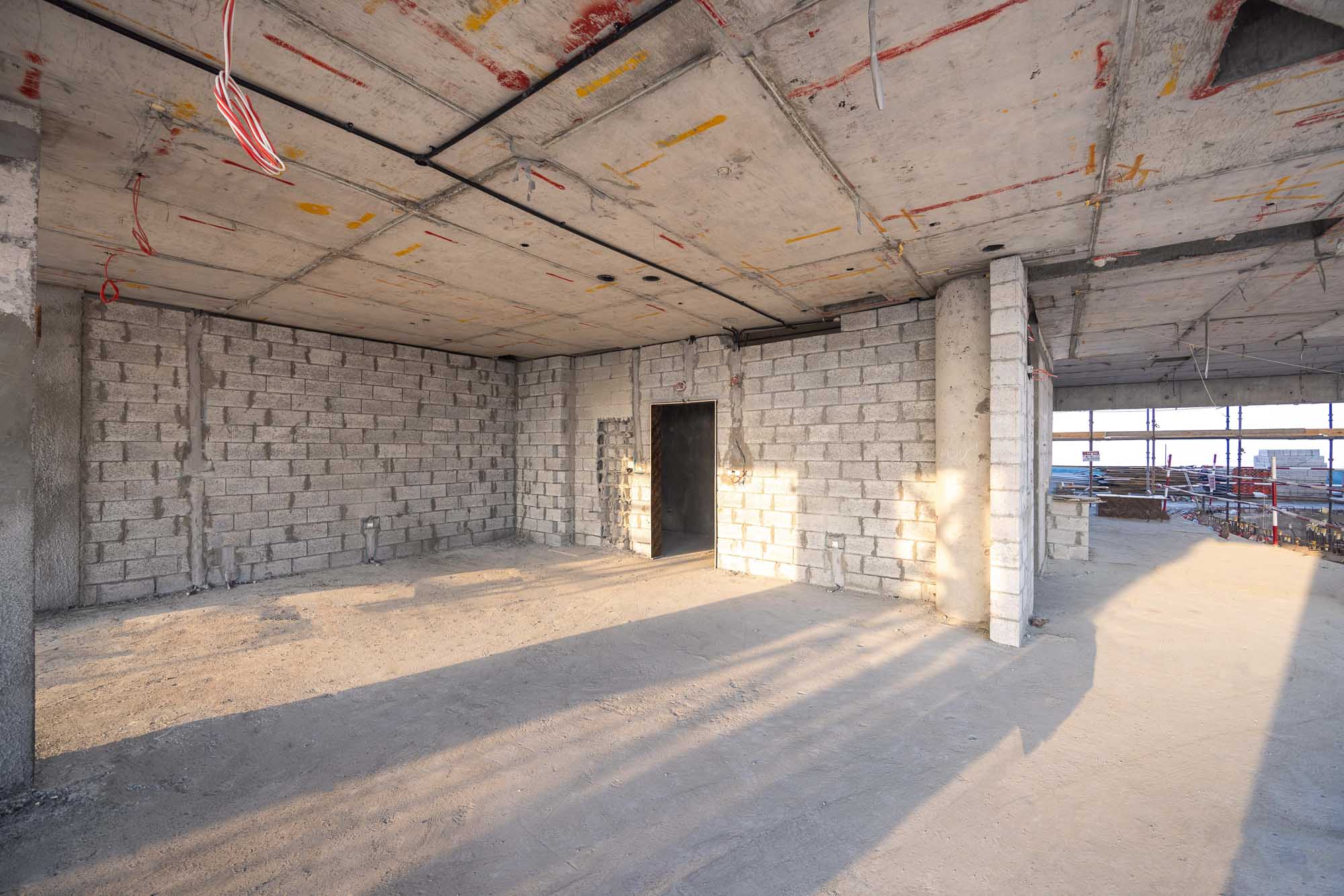 Beach Walk Iii By Imtiaz An empty construction site interior featuring concrete walls, unfinished floors, and exposed electrical wiring.