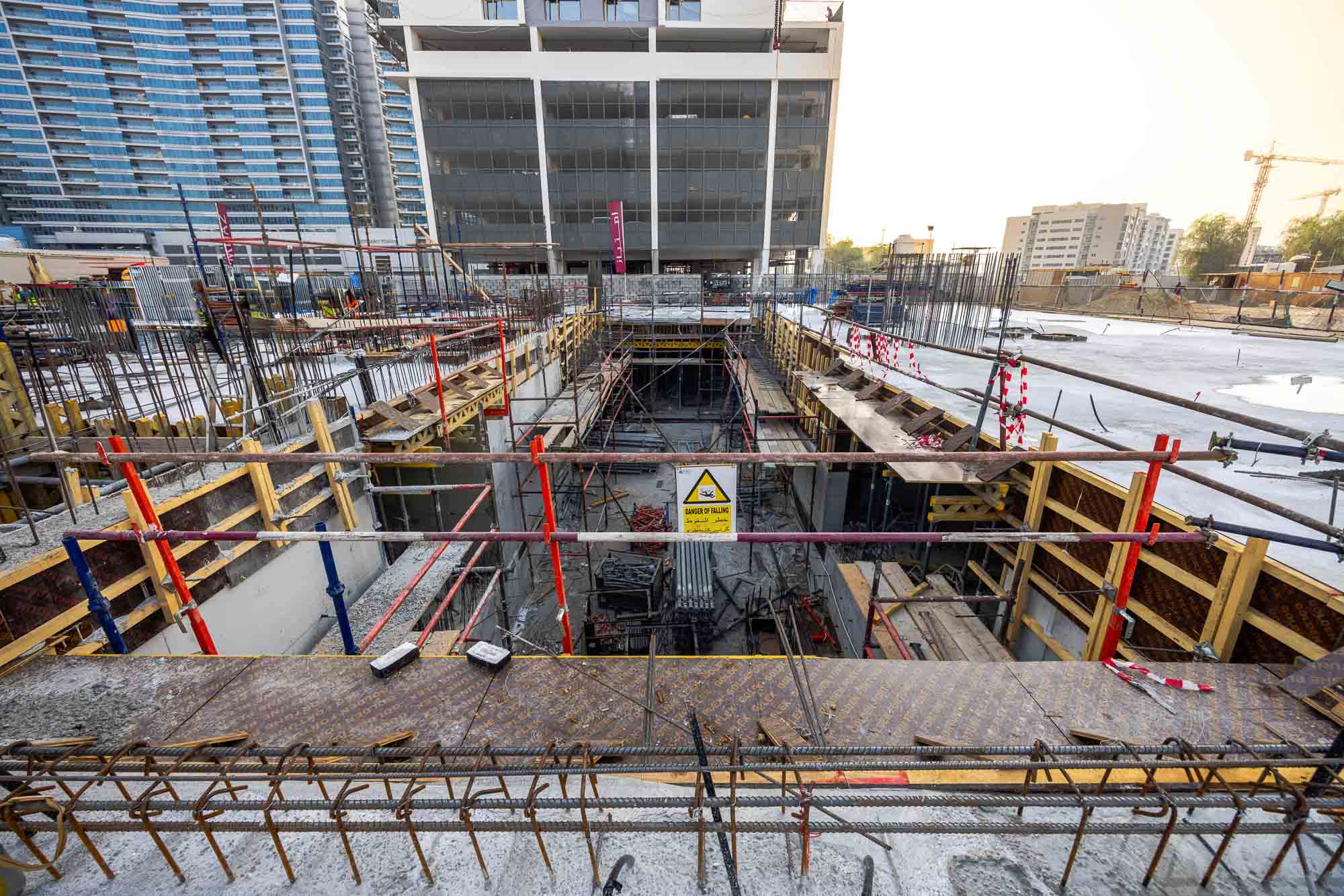 Cove Edition I By Imtiaz 1 Construction site showing deep foundations, scaffolding, and safety signage amidst ongoing building work.