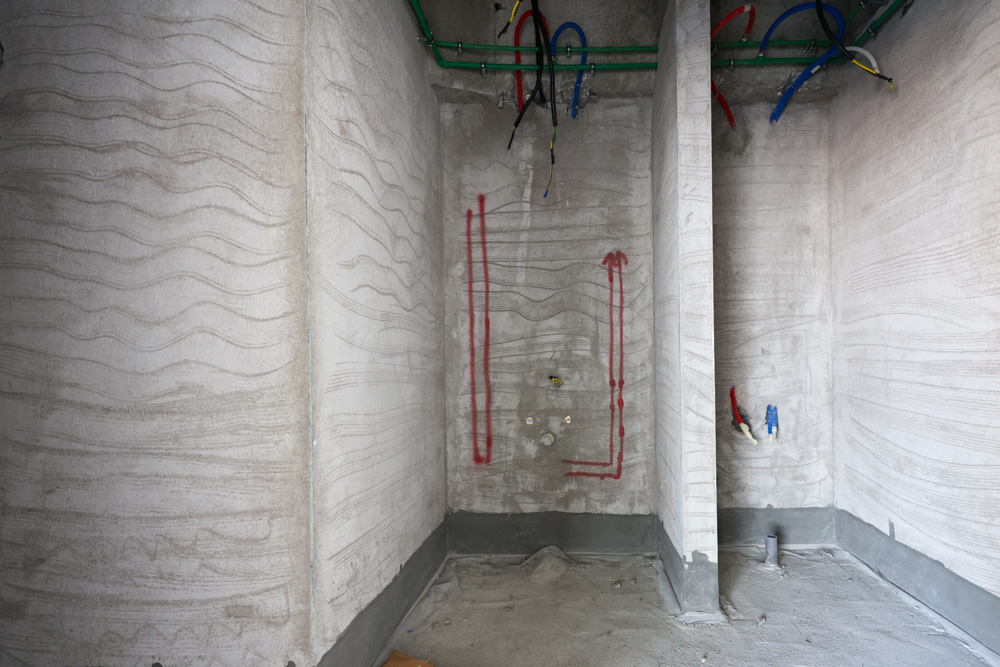 Beach Walk Iii By Imtiaz An unfinished room with textured walls, exposed electrical wiring, and marked plumbing locations.