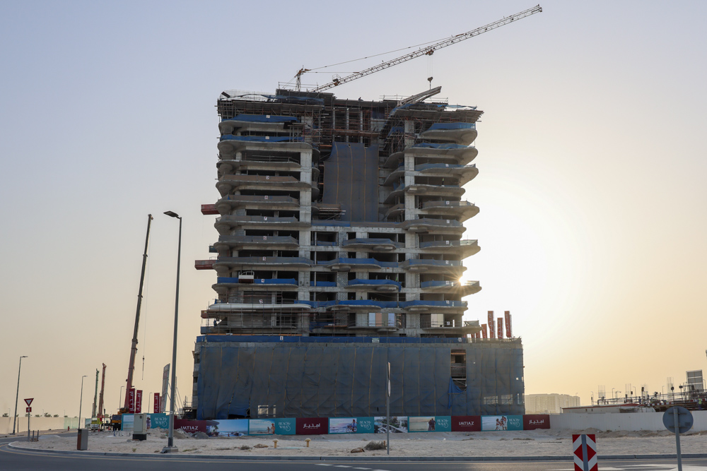 Beach Walk Iii By Imtiaz A partially constructed high-rise building under a clear sky, with a crane and scaffolding visible.