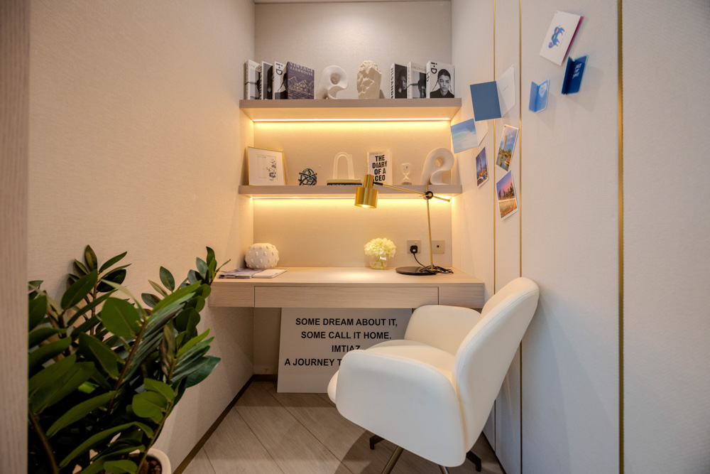Beach Walk Residence A cozy workspace featuring a desk, a white chair, books, plants, and inspirational quotes on the walls.