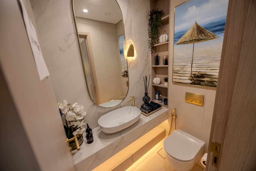 Beach Walk Residence Modern bathroom featuring a large mirror, rounded sink, stylish light, and decorative wall art. Elegant and well-designed space.