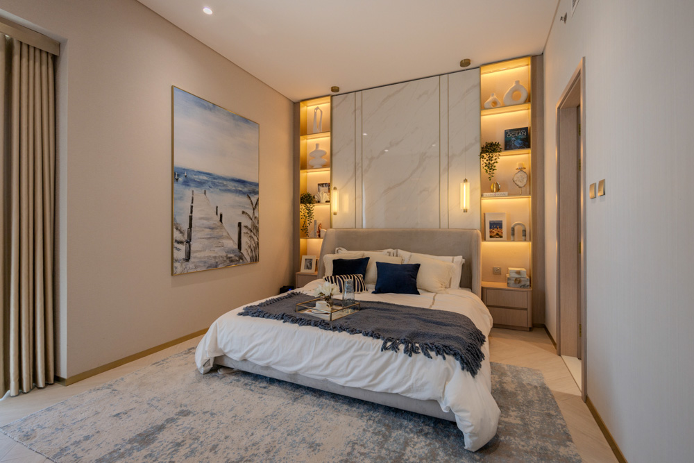 Beach Walk Residence A modern bedroom featuring a cozy bed with decorative pillows, stylish artwork, and contemporary lighting.