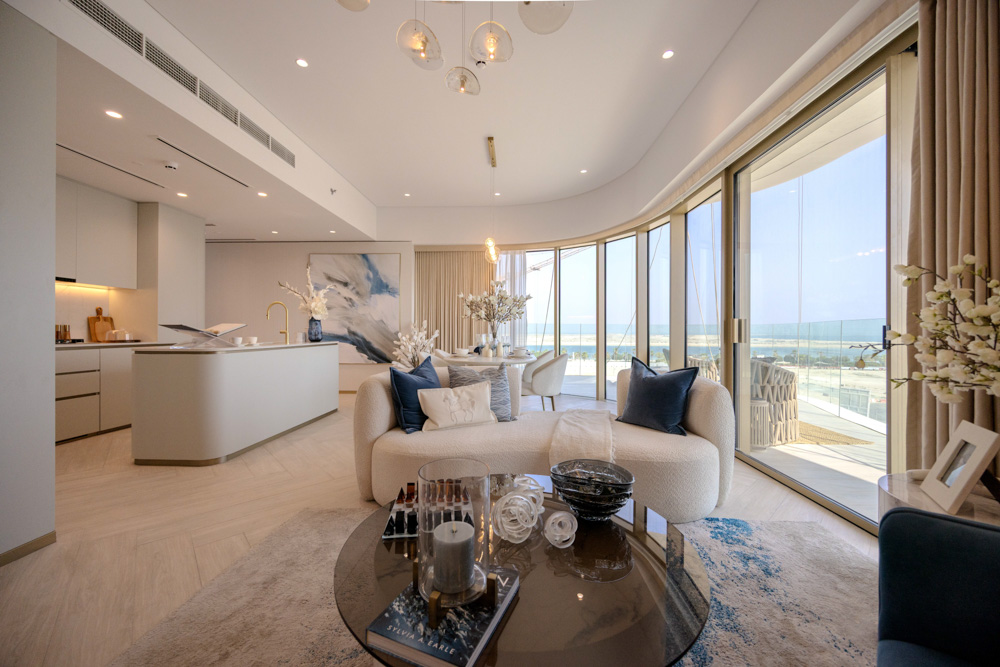 Beach Walk Residence A modern, stylish living space with a kitchen, elegant seating, and panoramic views of the ocean through large windows.