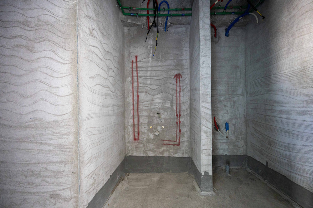 Beach Walk Iii By Imtiaz Interior view of a concrete room with textured walls, exposed pipes, and marked plumbing installations.