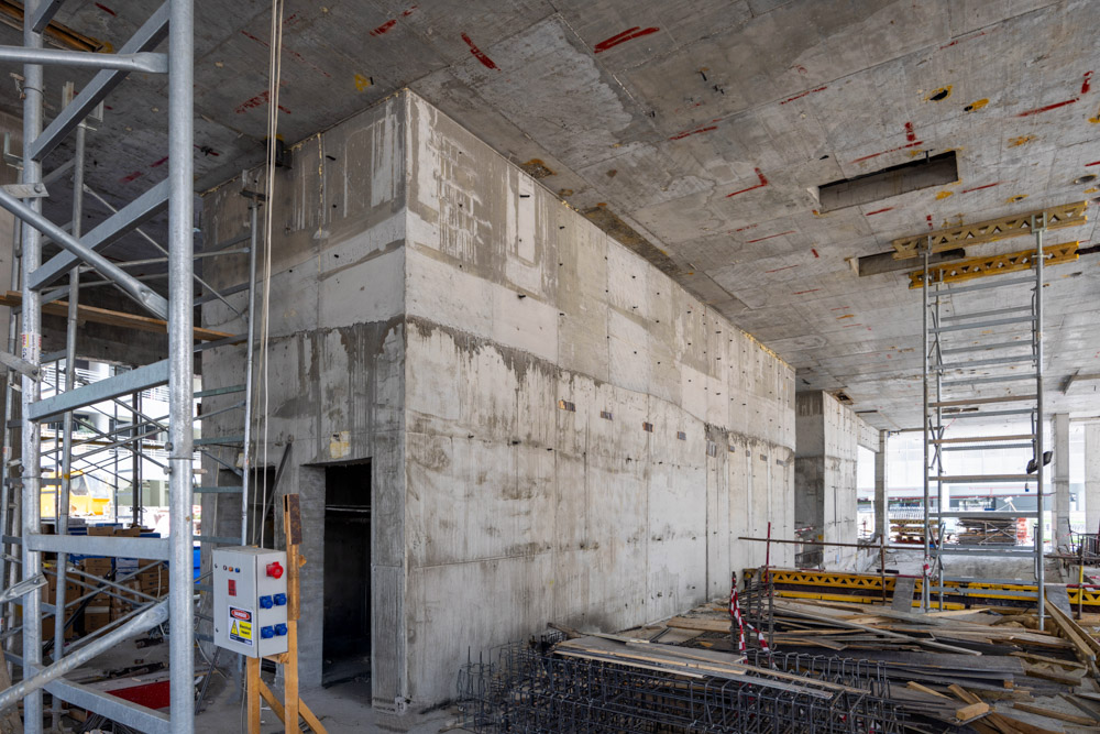 Cove Edition I By Imtiaz 1 Construction site featuring unfinished concrete walls, scaffolding, and scattered construction materials.