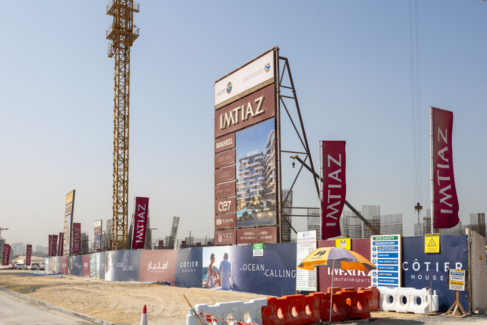 Cotier House 2 By Imtiaz Construction site showcasing a large sign for Imtiaz, with banners and a safety information board visible.