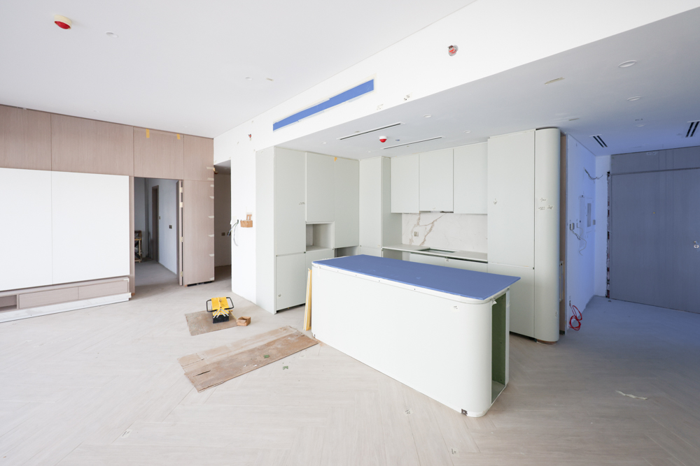 Beach Walk Residence An unfinished modern kitchen space featuring cabinets, an island, and construction materials on the floor.