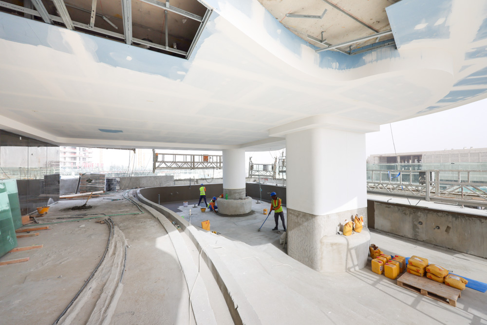 Beach Walk Residence Construction site interior showing workers, scaffolding, and unfinished structure with materials and tools.