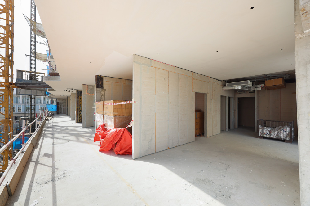 Cove Edition I By Imtiaz 1 A partially constructed building interior with exposed walls, construction materials, and scaffolding visible outside.