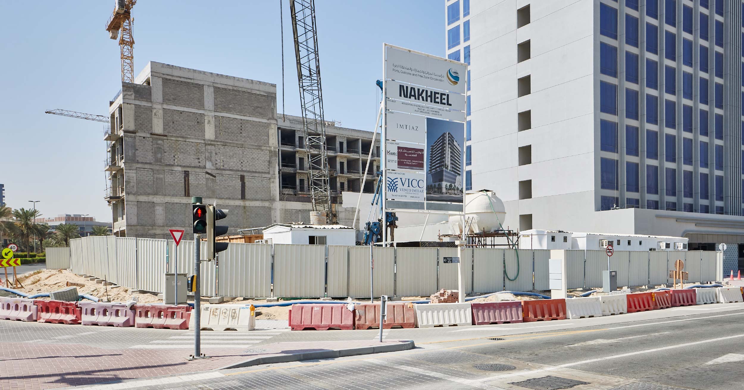 Pearl House By Imtiaz Construction site featuring a concrete building, construction machinery, barriers, and signage for Nakheel.