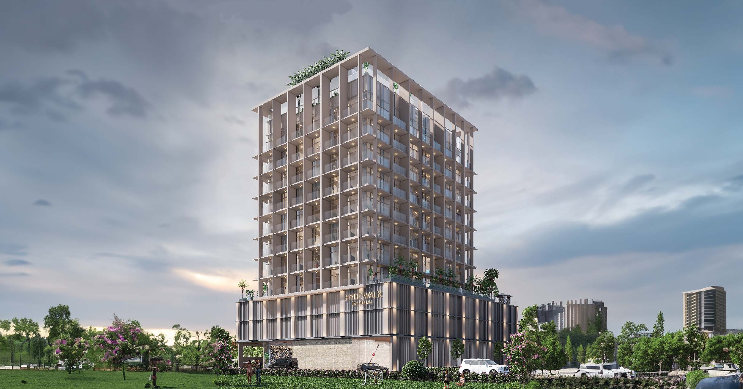 Hyde Walk By Imtiaz A modern multi-story building with balconies and greenery, surrounded by grass and scattered trees under a cloudy sky.