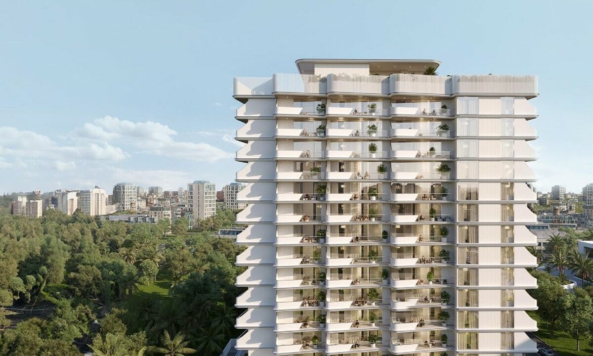 Cove Edition 2 By Imtiaz Modern residential building with multiple balconies, set against a city skyline and green landscape in the foreground.