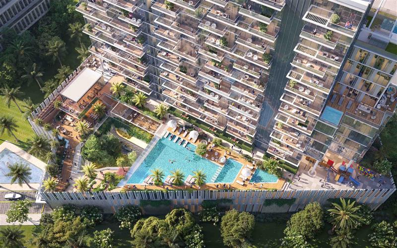Wynwood By Imtiaz Aerial view of a modern building with lush greenery, a swimming pool, and outdoor seating areas.