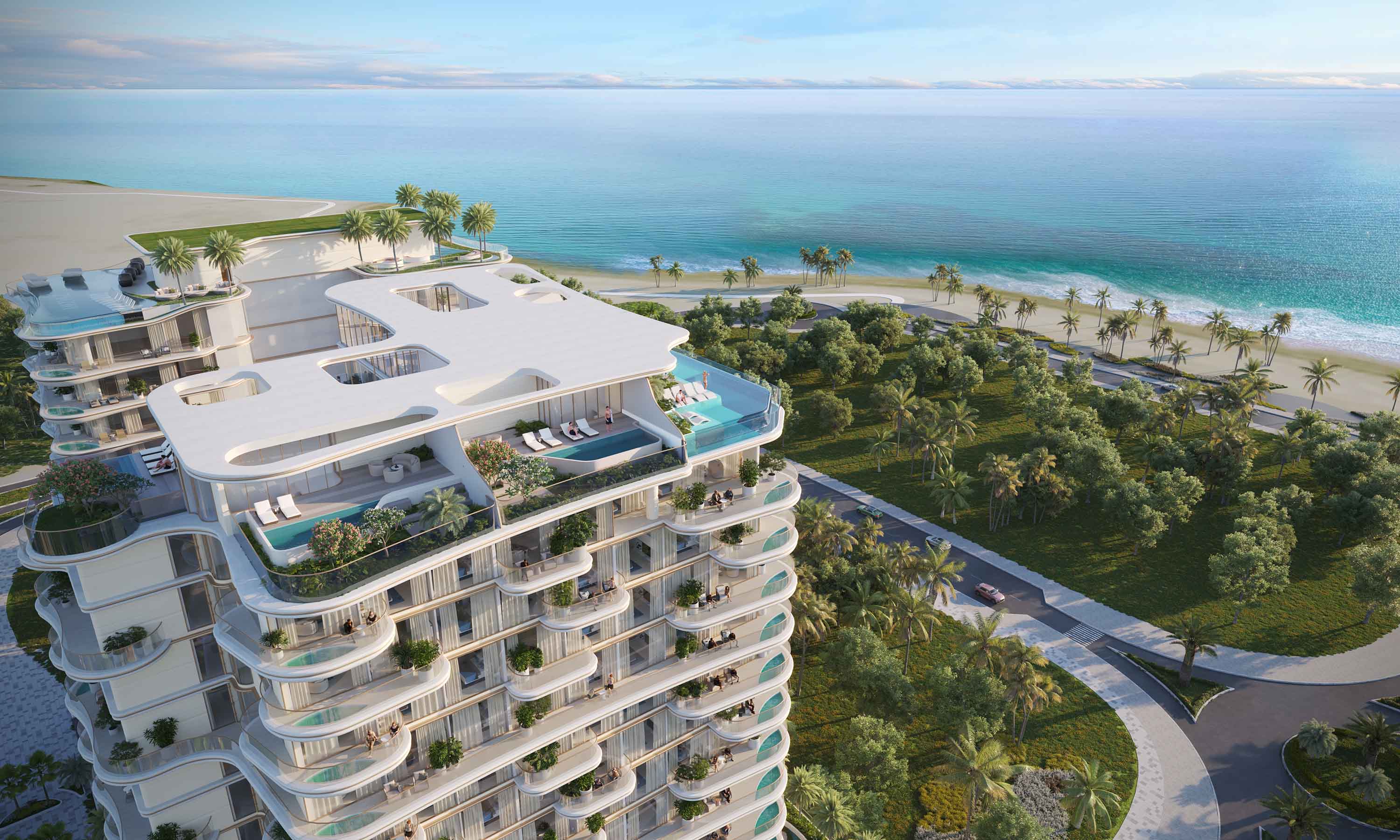 Beach Walk Grand 2 By Imtiaz Aerial view of a luxury beachfront condominium with pools, surrounded by palm trees and a scenic ocean view.