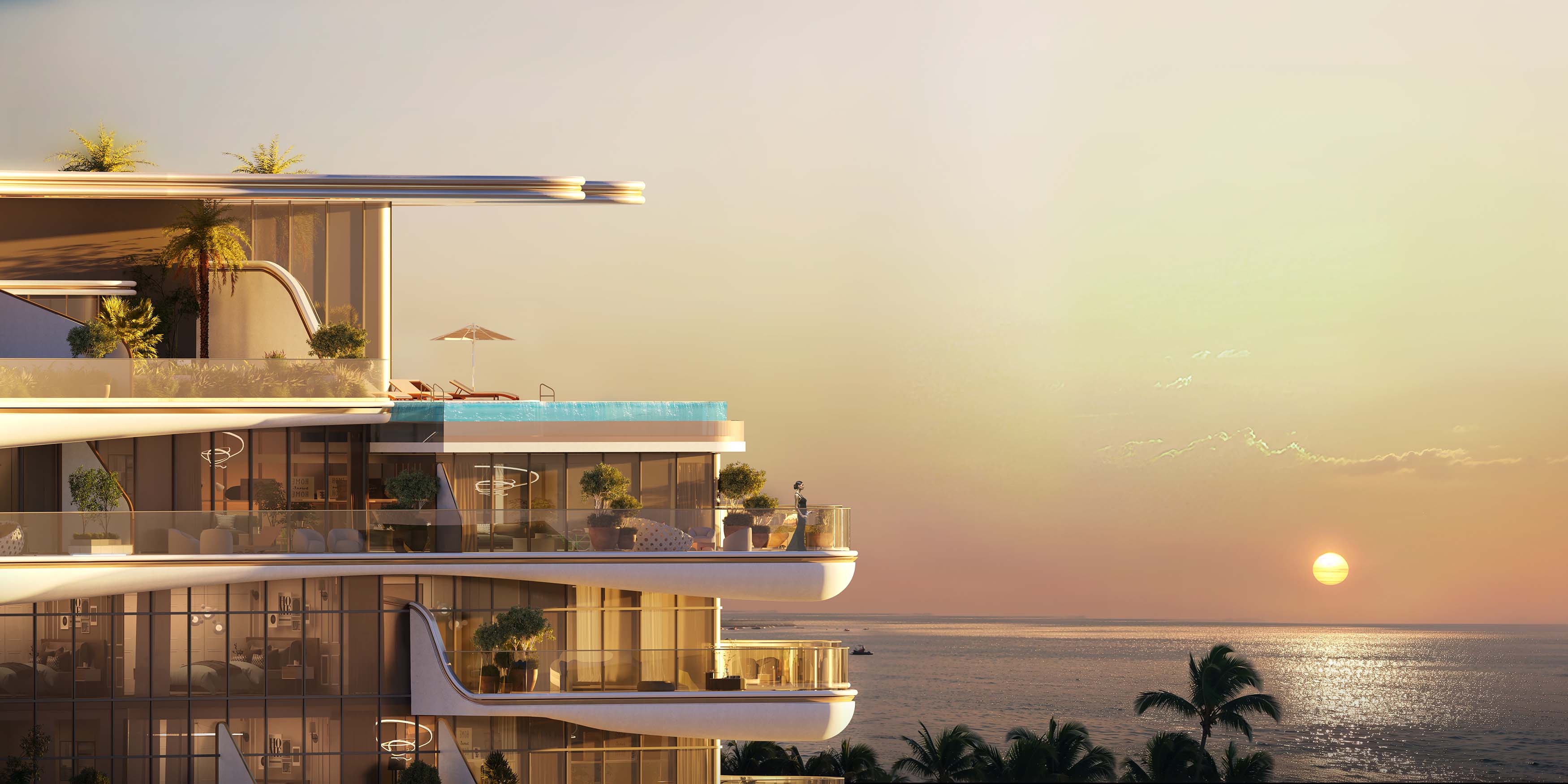 Beach Walk Grand By Imtiaz A modern beachfront building with lush balconies, a pool, and sunset over the ocean in the background.