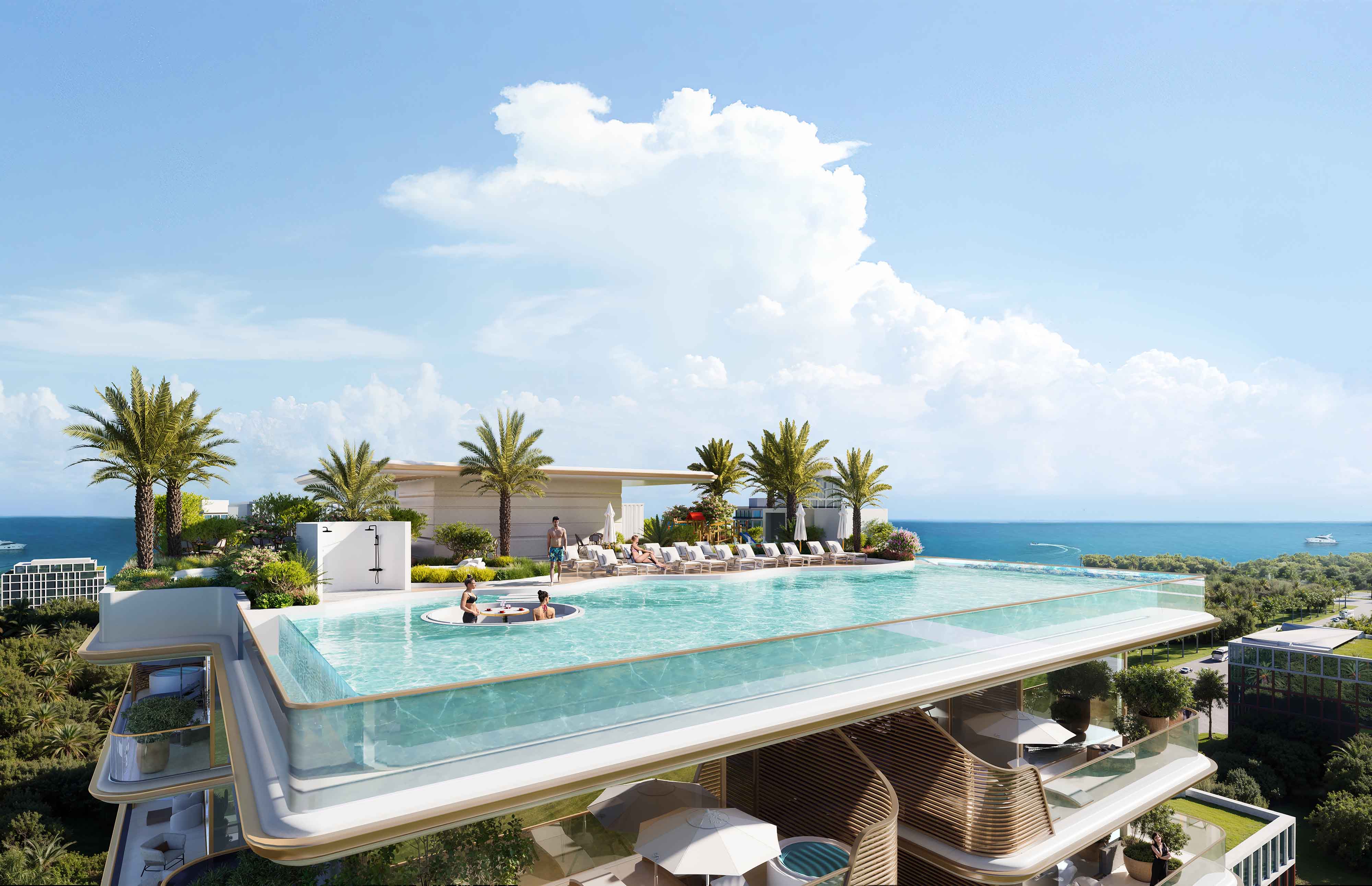 Sunset Bay 5 By Imtiaz A luxurious rooftop pool with sun loungers, palm trees, and ocean views under a clear blue sky.