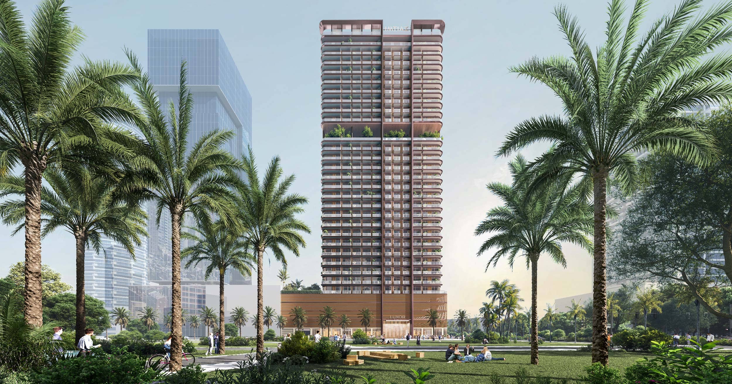 Luxor By Imtiaz A modern high-rise building surrounded by palm trees and green spaces, with people enjoying the park area.