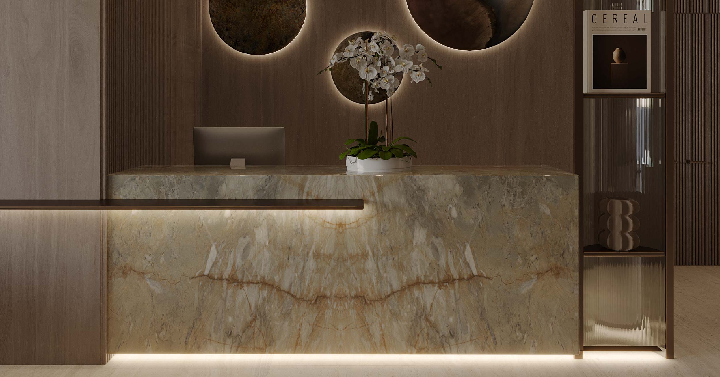 Pearl House Iii By Imtiaz A modern reception area featuring a marble counter, an orchid plant, circular wall decor, and soft lighting.